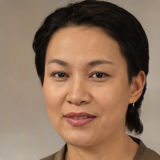 Joyful latino adult female with medium  brown hair and brown eyes