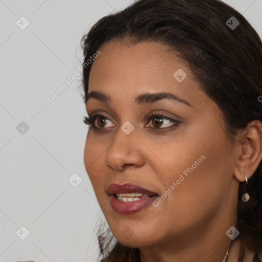 Joyful black young-adult female with long  brown hair and brown eyes