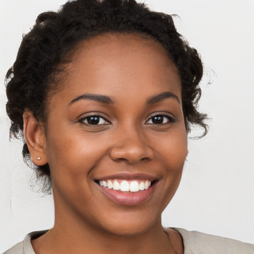 Joyful black young-adult female with medium  brown hair and brown eyes