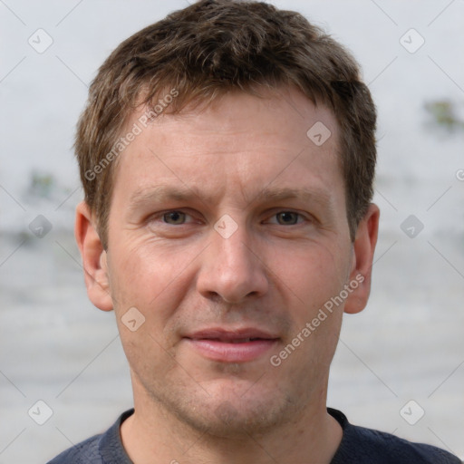 Joyful white adult male with short  brown hair and grey eyes