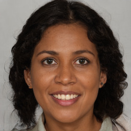 Joyful black adult female with long  brown hair and brown eyes