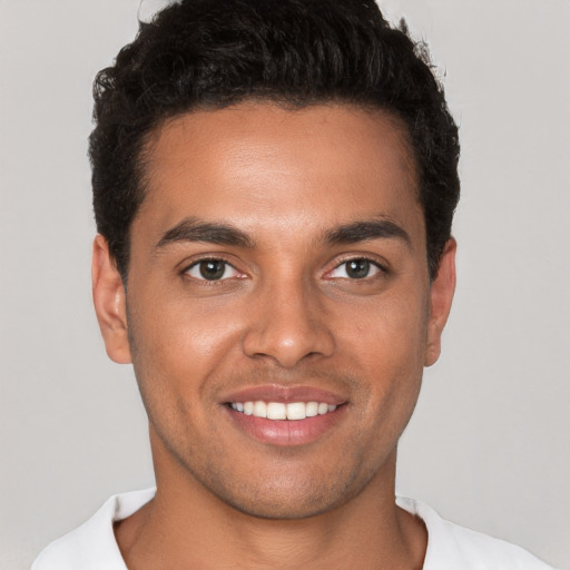 Joyful white young-adult male with short  black hair and brown eyes