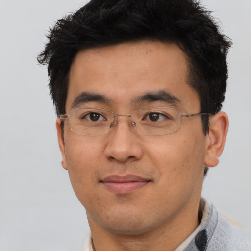 Joyful asian adult male with short  black hair and brown eyes