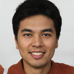 Joyful latino young-adult male with short  brown hair and brown eyes