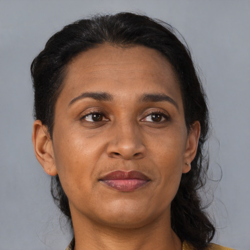 Joyful black adult female with medium  brown hair and brown eyes