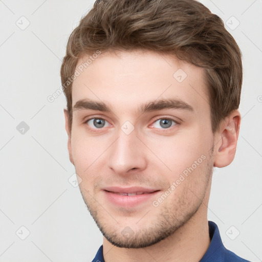 Joyful white young-adult male with short  brown hair and grey eyes