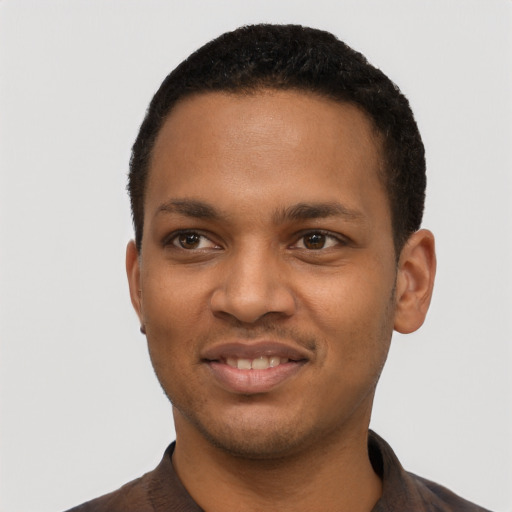 Joyful black young-adult male with short  black hair and brown eyes