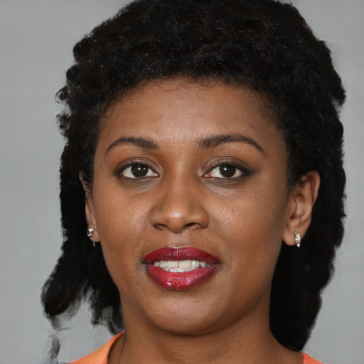 Joyful black young-adult female with short  brown hair and brown eyes