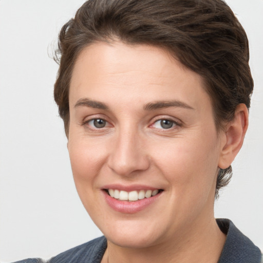 Joyful white young-adult female with short  brown hair and grey eyes