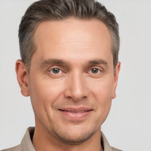 Joyful white adult male with short  brown hair and brown eyes