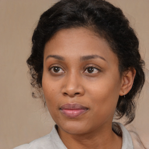Joyful black young-adult female with medium  brown hair and brown eyes