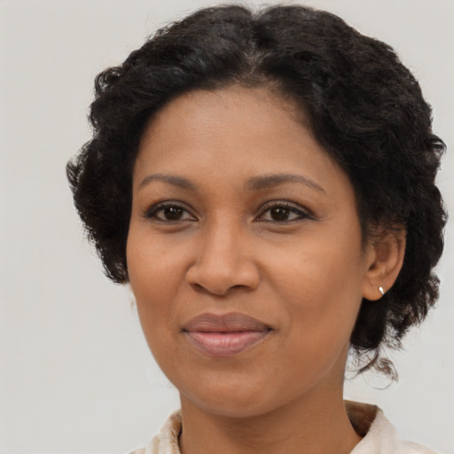 Joyful black adult female with medium  brown hair and brown eyes
