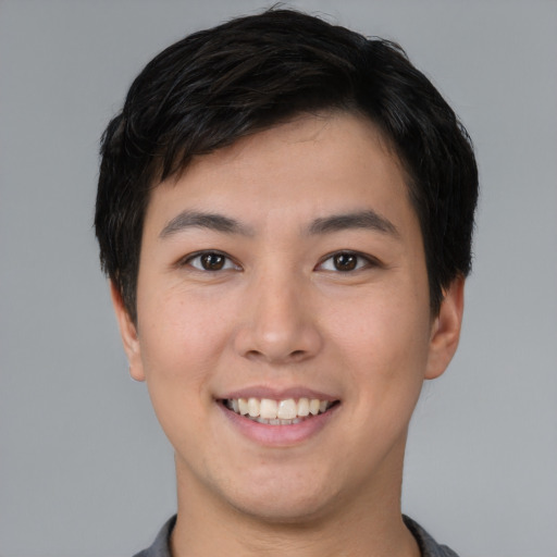 Joyful asian young-adult male with short  black hair and brown eyes