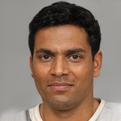 Joyful black adult male with short  black hair and brown eyes