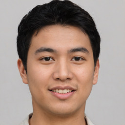 Joyful asian young-adult male with short  black hair and brown eyes