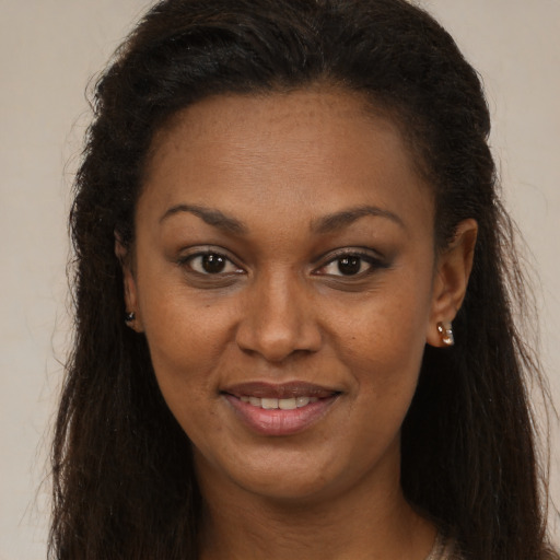 Joyful black young-adult female with long  brown hair and brown eyes
