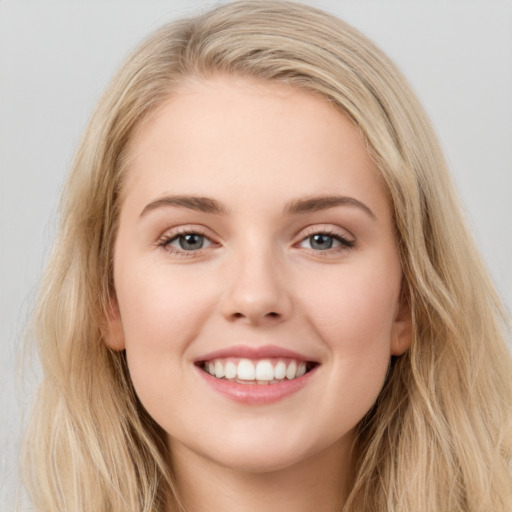 Joyful white young-adult female with long  brown hair and blue eyes