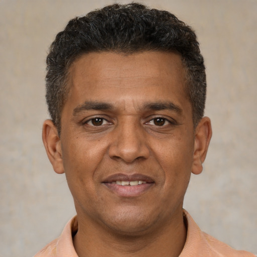Joyful black young-adult male with short  brown hair and brown eyes