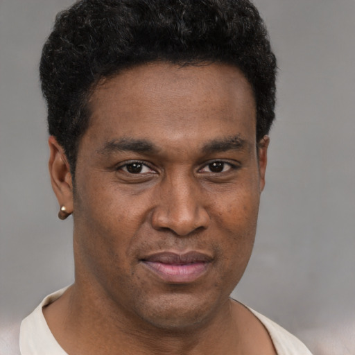 Joyful black young-adult male with short  brown hair and brown eyes