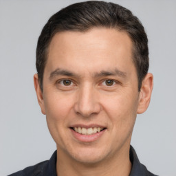 Joyful white young-adult male with short  brown hair and brown eyes