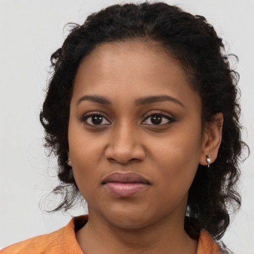 Joyful black young-adult female with long  brown hair and brown eyes
