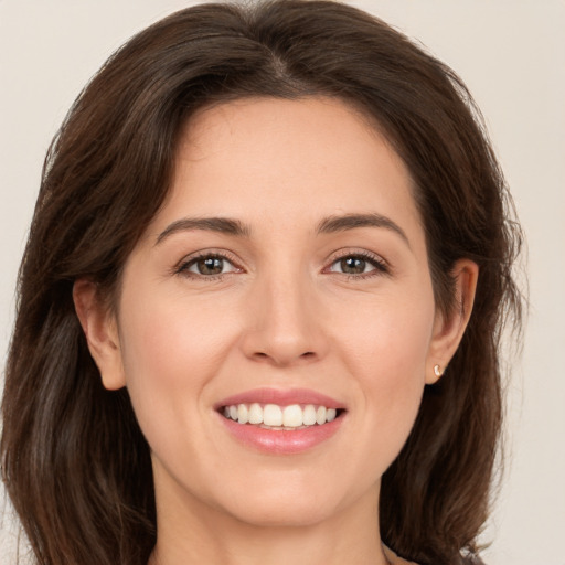 Joyful white young-adult female with long  brown hair and brown eyes