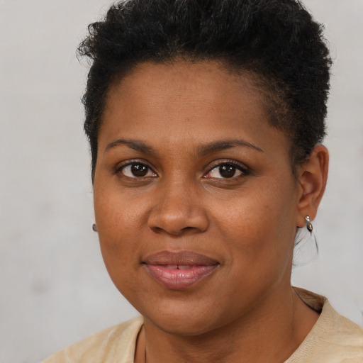 Joyful black young-adult female with short  brown hair and brown eyes