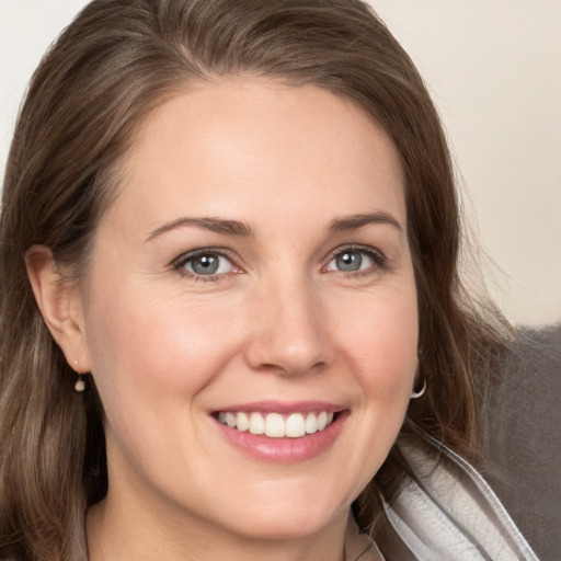 Joyful white young-adult female with medium  brown hair and grey eyes