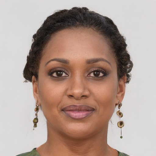 Joyful black young-adult female with medium  brown hair and brown eyes
