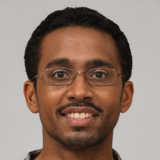 Joyful black young-adult male with short  black hair and brown eyes