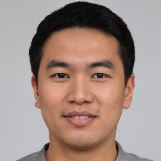 Joyful asian young-adult male with short  black hair and brown eyes