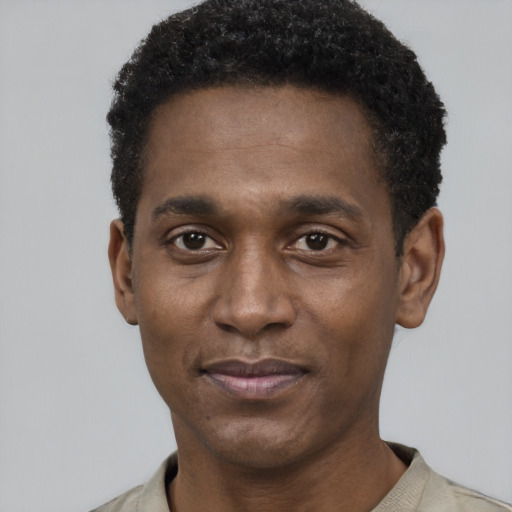 Joyful black young-adult male with short  black hair and brown eyes