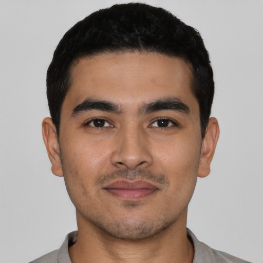 Joyful latino young-adult male with short  black hair and brown eyes