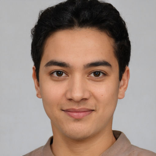 Joyful latino young-adult male with short  black hair and brown eyes