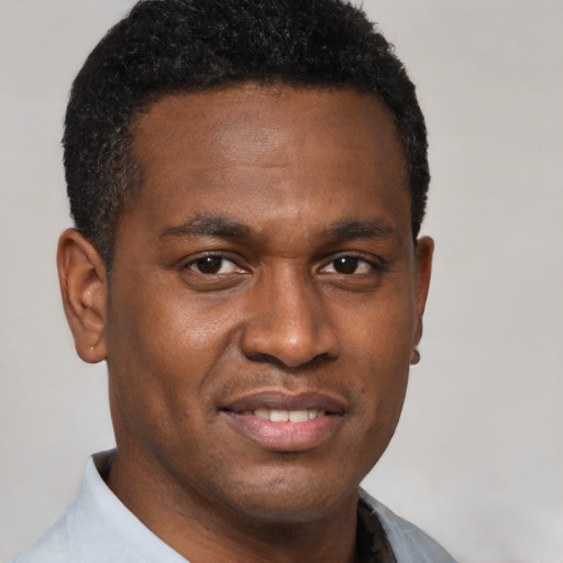 Joyful black young-adult male with short  black hair and brown eyes