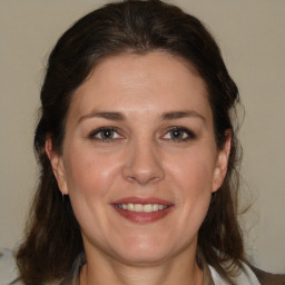 Joyful white adult female with medium  brown hair and brown eyes