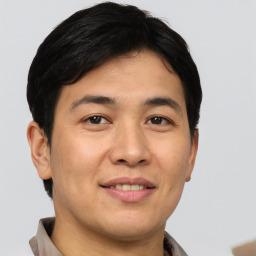 Joyful asian young-adult male with short  brown hair and brown eyes