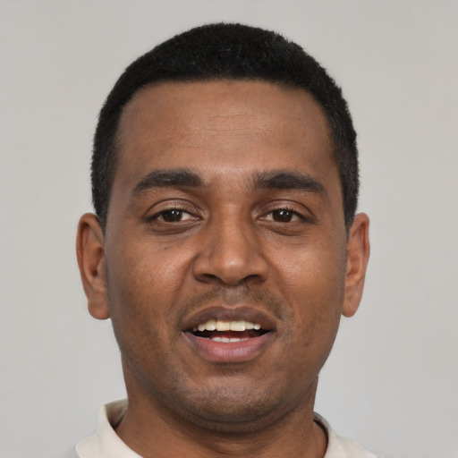 Joyful black young-adult male with short  black hair and brown eyes