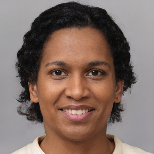 Joyful black young-adult female with short  brown hair and brown eyes