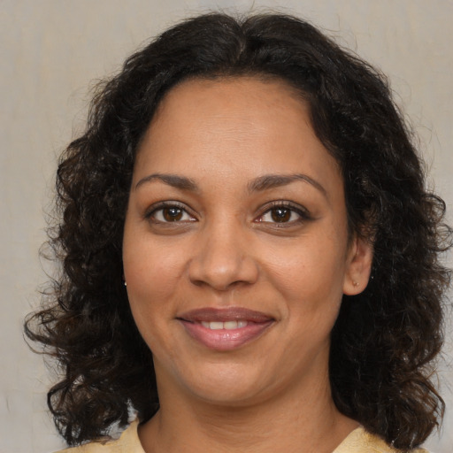 Joyful black adult female with medium  brown hair and brown eyes