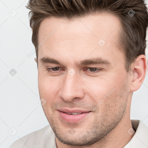 Joyful white young-adult male with short  brown hair and brown eyes