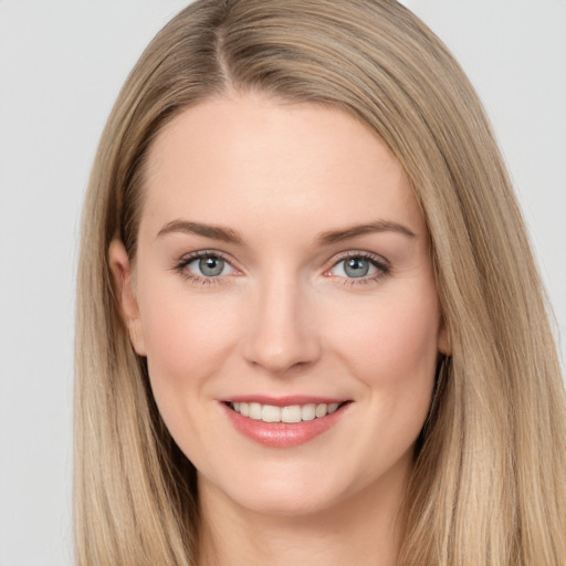 Joyful white young-adult female with long  brown hair and grey eyes