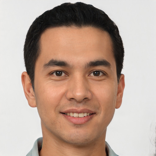 Joyful latino young-adult male with short  black hair and brown eyes