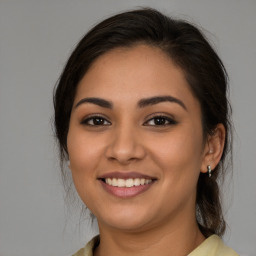 Joyful latino young-adult female with medium  brown hair and brown eyes