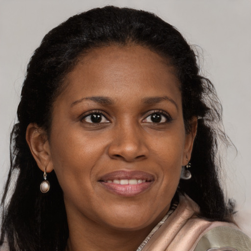 Joyful black young-adult female with long  brown hair and brown eyes