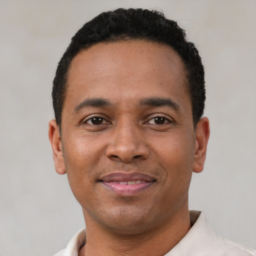 Joyful latino young-adult male with short  brown hair and brown eyes
