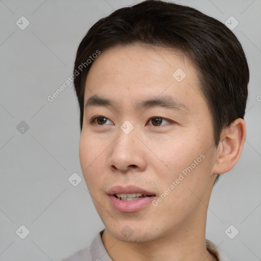 Joyful asian young-adult male with short  brown hair and brown eyes