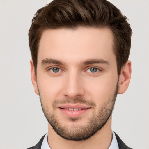 Joyful white young-adult male with short  brown hair and grey eyes