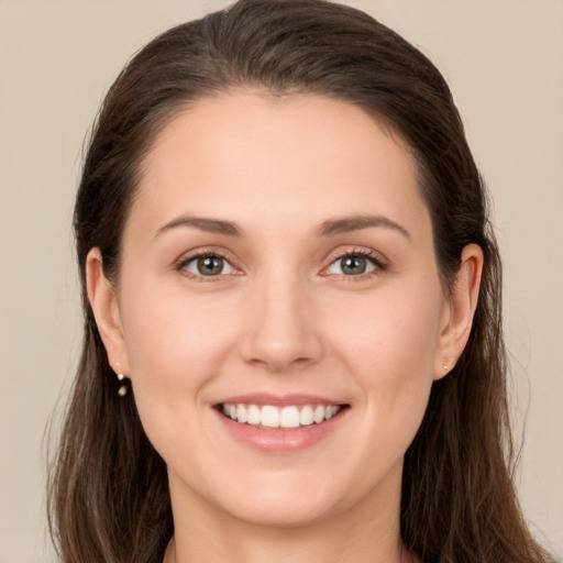 Joyful white young-adult female with long  brown hair and brown eyes