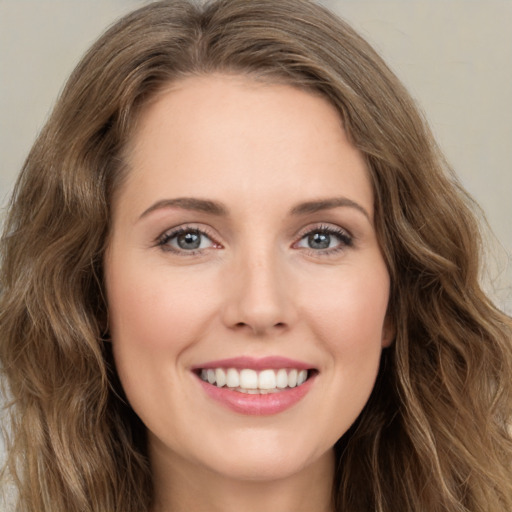 Joyful white young-adult female with long  brown hair and green eyes